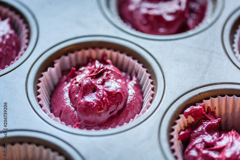 Close up. Raw dough for cupcake in baking tray. Process of cupcakes preparation. Homemade Red Velvet Cupcakes. Soft focus.