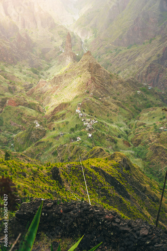 Mountain peaks of Xo-Xo valley in sun light. Local village in the valley. Many agava plants grow on the steep stony slopes. Santa Antao island, Cape Verde photo