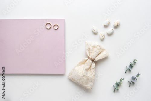 Wedding wish book, candy, weddings rings and oregano branches. Top view.