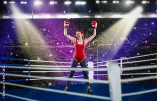 Female boxer in red sportswear hands up on ring © Nomad_Soul