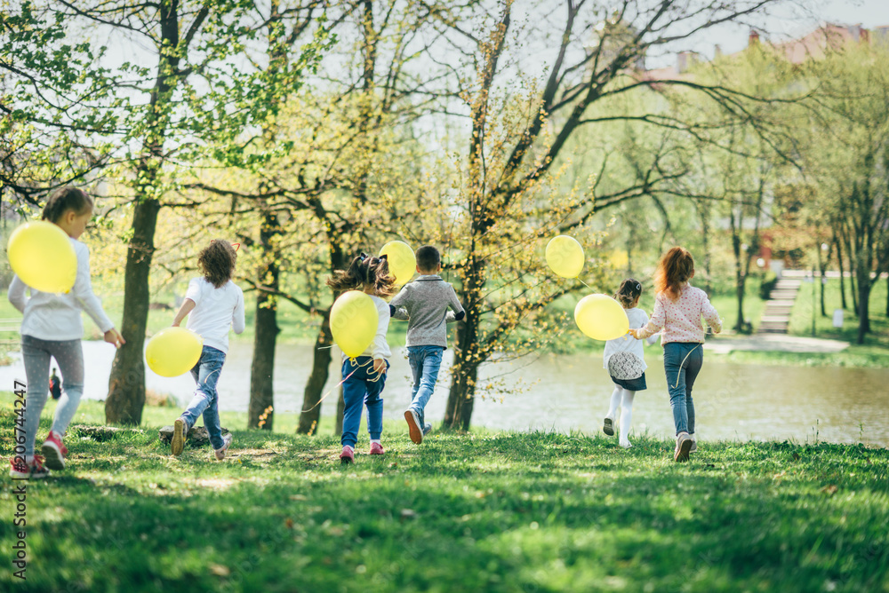 Children with yellow balloons running in the park Children with yellow balloons running in the park