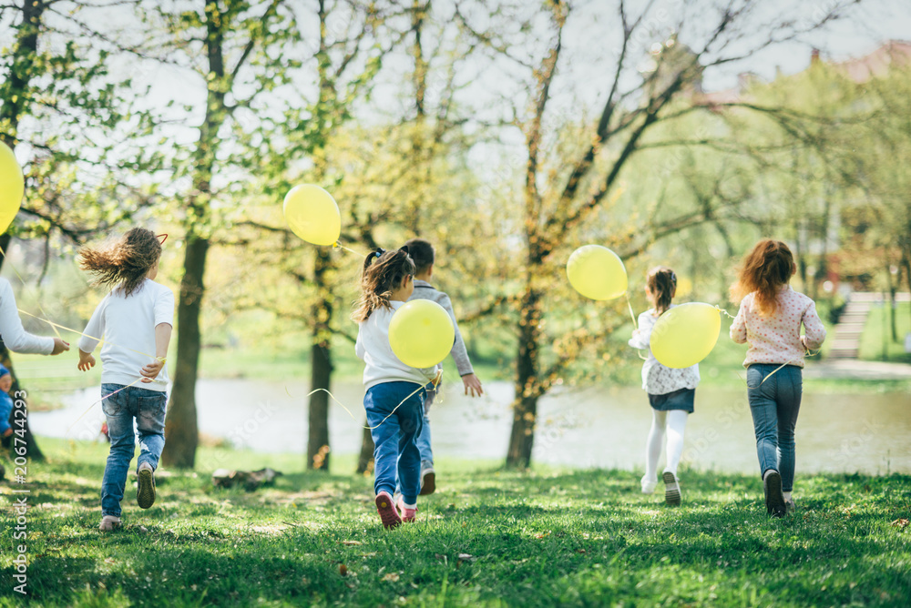 Obraz premium Children with yellow balloons playing together