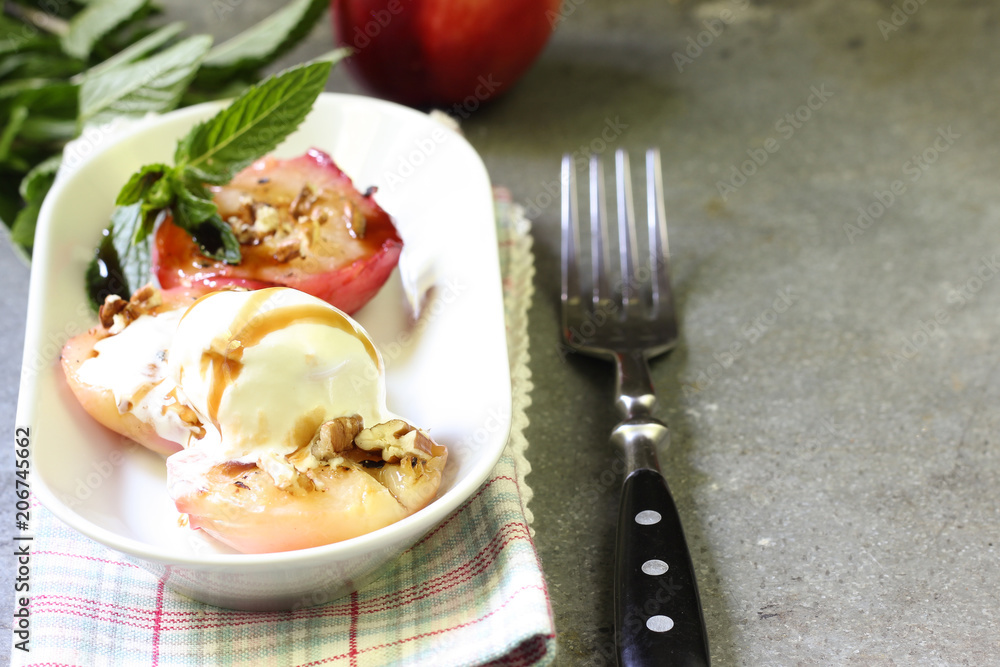 Baked peaches with ice cream on a plate on a gray metal background Baked peaches with ice cream on a plate on a gray metal background