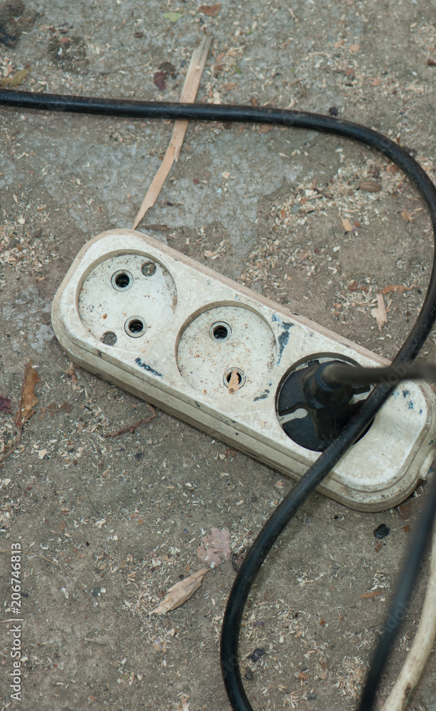 the vertical view of power socket with included forks on the asphalt
