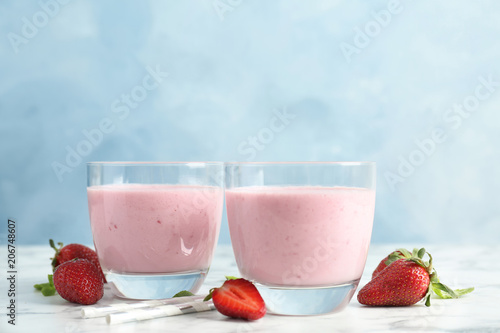 Glasses with healthy detox smoothie and strawberries on table