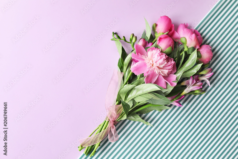 Bouquet of beautiful peony flowers on color background, top view