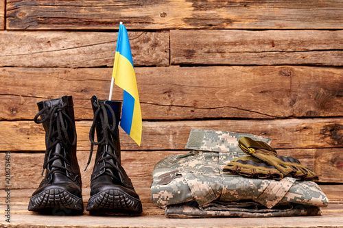 Folded ukraine army soldier uniform. Brown wooden desk surface background.