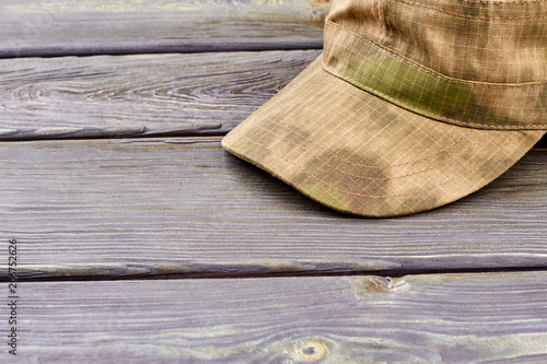 Military cap close up. Wooden desk surface background.