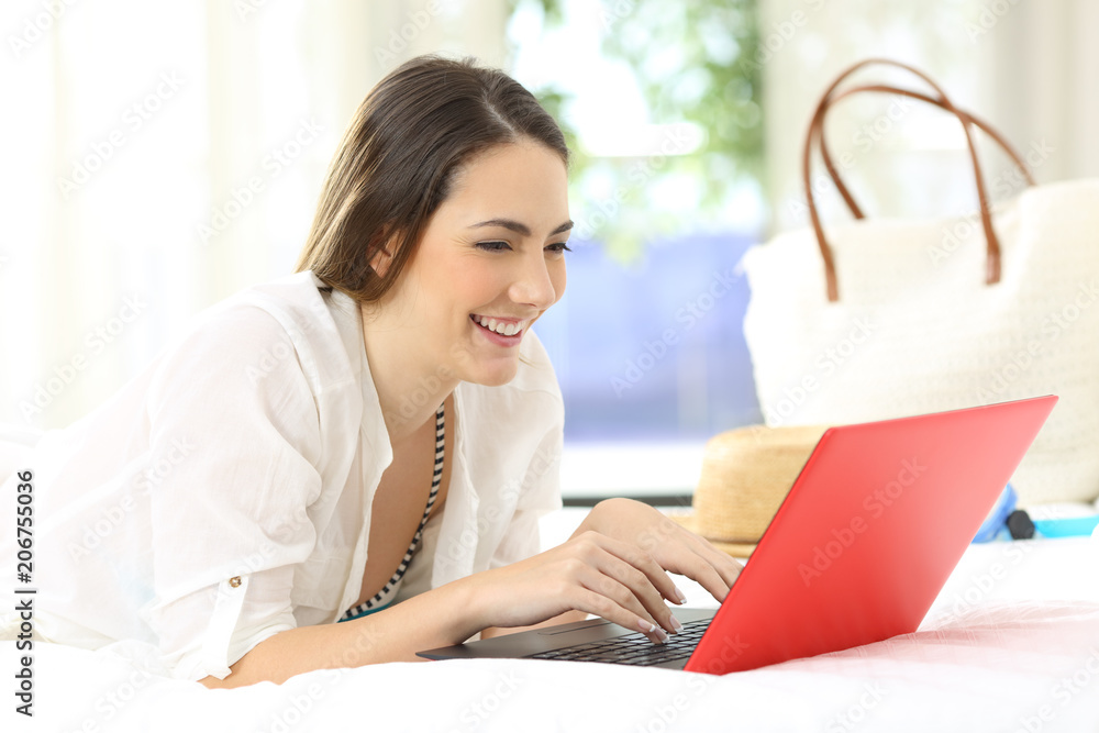 Hotel guest using a laptop in a room on summer holidays Hotel guest using a laptop in a room on summer holidays