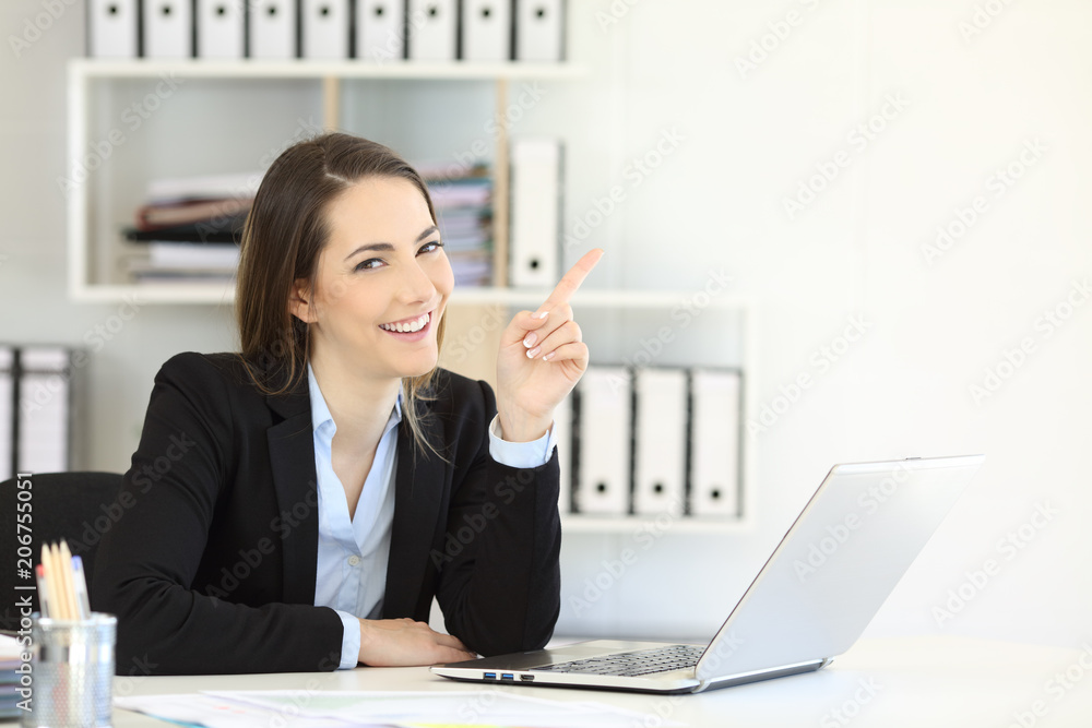 Office worker pointing at side and looking at camera Office worker pointing at side and looking at camera