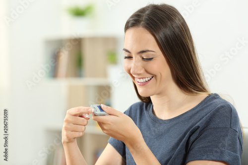 Cuadro en lienzo Happy diabetic girl checking blood sugar level
