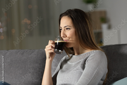 Relaxed woman drinking decaffeinated coffee in the night