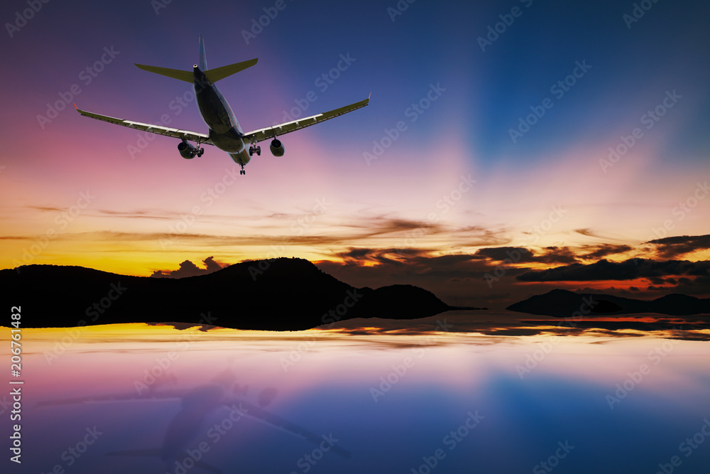 Airplane flying over tropical sea at beautiful light sunset or sunrise with reflex in the water at phuket thailand scenery background.