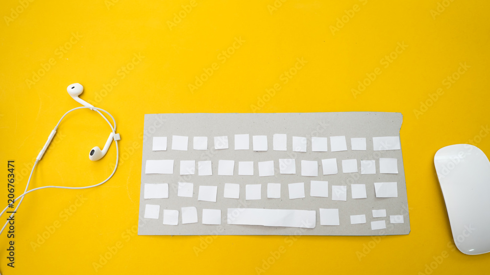 Office desk table Top view with keyboard and earphone yellow background Office desk table Top view with keyboard and earphone yellow background