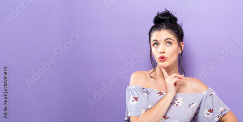 Young woman in a thoughtful pose on a solid background