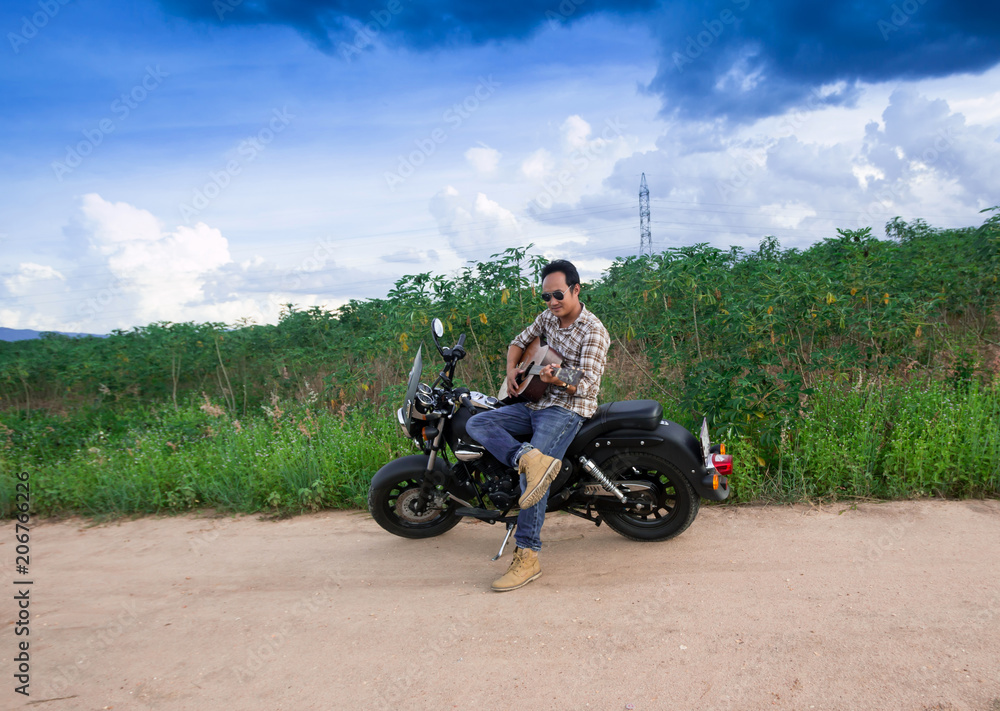 Men  Play guitar with  motorcycle in the countryside
