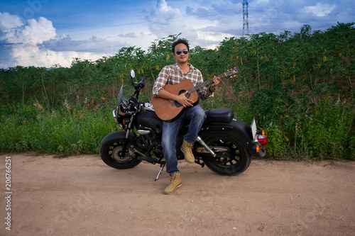 Men  Play guitar with  motorcycle in the countryside  