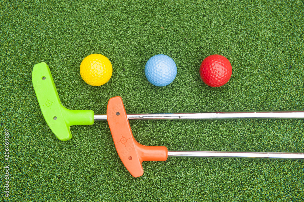 Foto Stock Two Mini Golf Putters and Three Balls | Adobe Stock