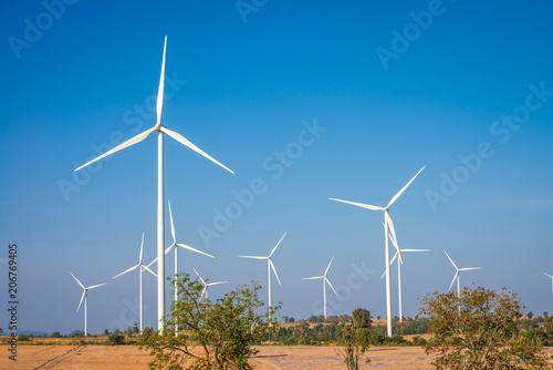 Wind turbines generating electricity on mountain with blue sky