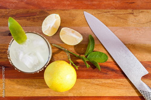 Key lime margarita garnished with fresh lime in a glass bar table knife. view from above photo