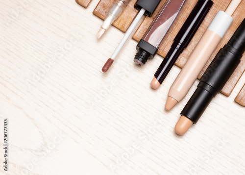 Different types of make-up concealers on white wooden table