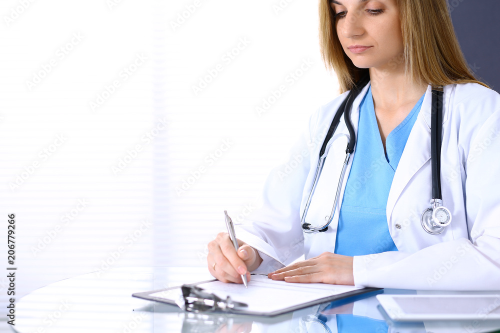 Woman doctor at work in hospital office. Portrait of female physician. Medicine and health care concept Woman doctor at work in hospital office. Portrait of female physician. Medicine and health care concept