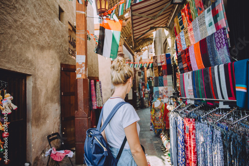 Back view of young female traveller at traditional bazaar in Dubai, UAE