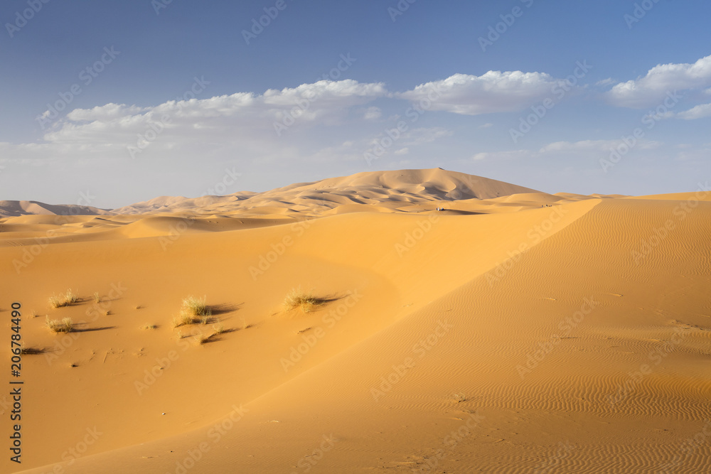 blue sky with clouds above dunes in Sahara desert in Morocco