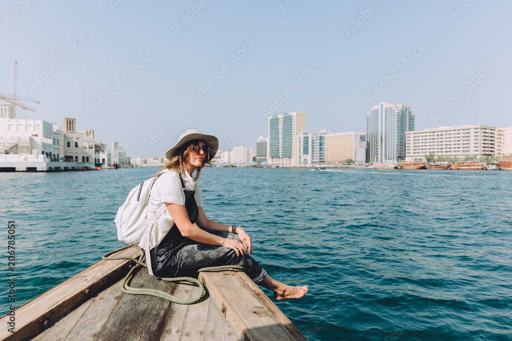 Young beautiful woman sitting at boat and looking at sea and the city DUbai Young beautiful woman sitting at boat and looking at sea and the city DUbai