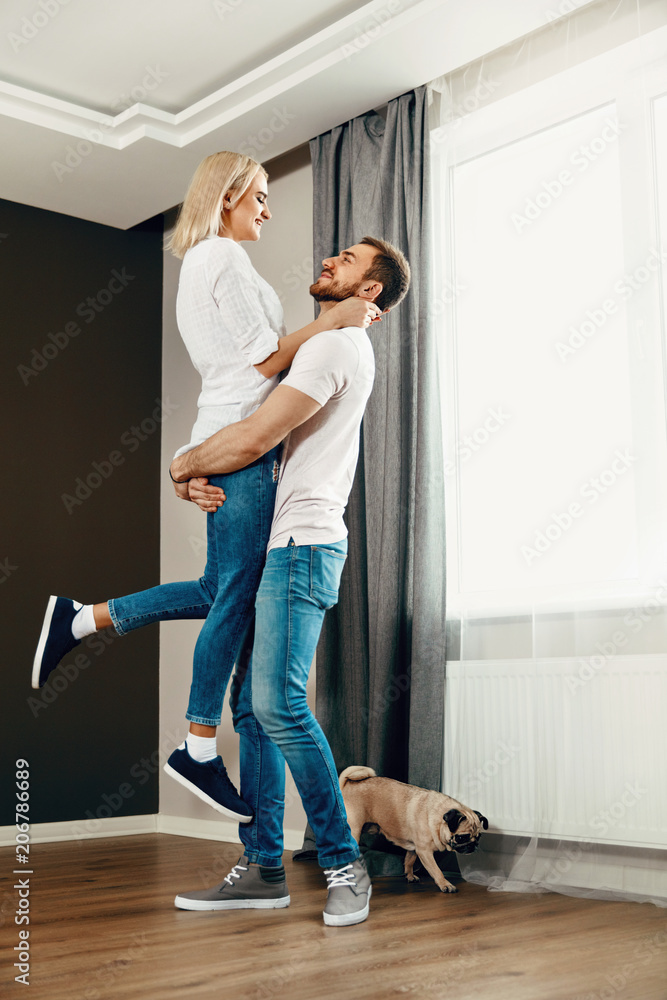 Moving Day. Man Hugging Woman In New Home Moving Day. Man Hugging Woman In New Home