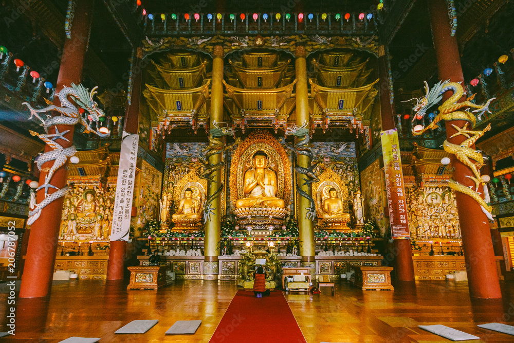 Golden Buddha statues inside Yakcheonsa Temple. Jeju, South Korea.