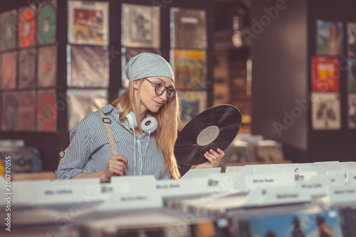 Foto Young girl in a vinyl record store