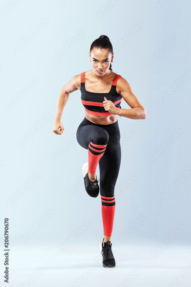 A strong athletic, women sprinter, running wearing in the sportswear, fitness and sport motivation. Runner concept with copy space. Dynamic movement