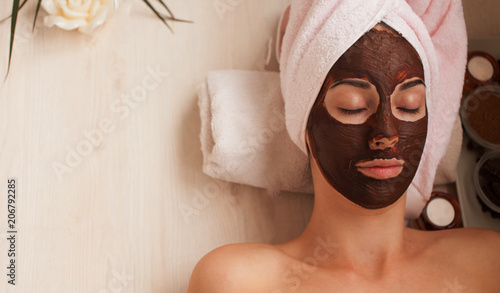 Chocolate Luxury Spa. Facial Mask. Spa therapy for young woman with cosmetic mask at beauty salon. Day spa treatment