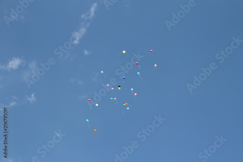 красивые разноцветные воздушные шары улетают в голубое небо 