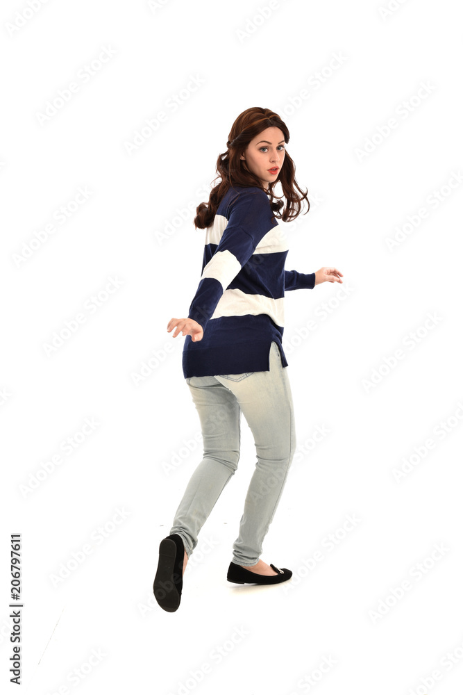 full length portrait of girl wearing striped blue and white jumper and jeans. standing pose facing away from the camera, on white studio background full length portrait of girl wearing striped blue and white jumper and jeans. standing pose facing away from the camera, on white studio background