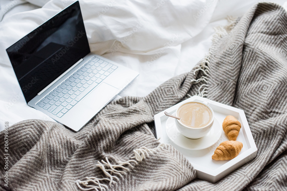 Cozy weekend at home, laptop and coffee in bed Cozy weekend at home, laptop and coffee in bed