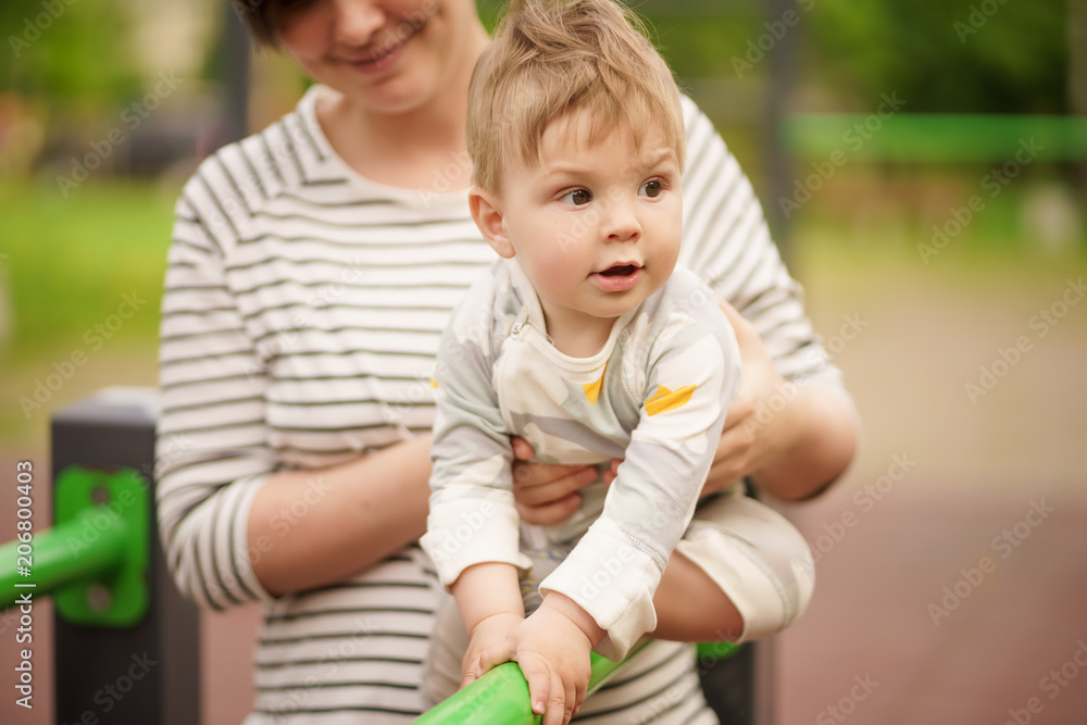 Concept: family values. Portrait of adorable innocent funny brown-eyed baby smiling and playing with his mom. Concept: family values. Portrait of adorable innocent funny brown-eyed baby smiling and playing with his mom.