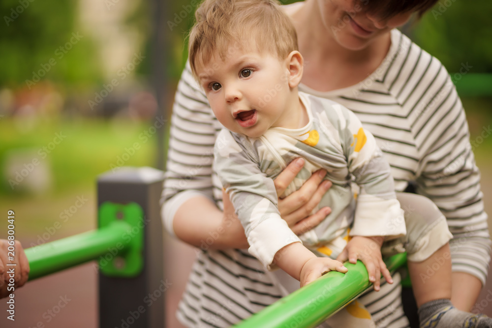 Concept: family values. Portrait of adorable innocent funny brown-eyed baby smiling and playing with his mom. Concept: family values. Portrait of adorable innocent funny brown-eyed baby smiling and playing with his mom.