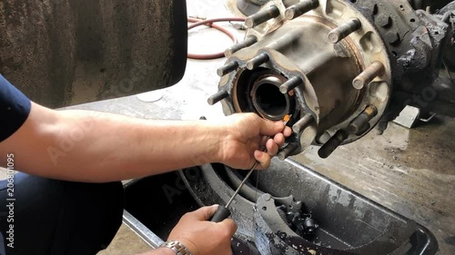 Close up of hands working on truck axel for repair