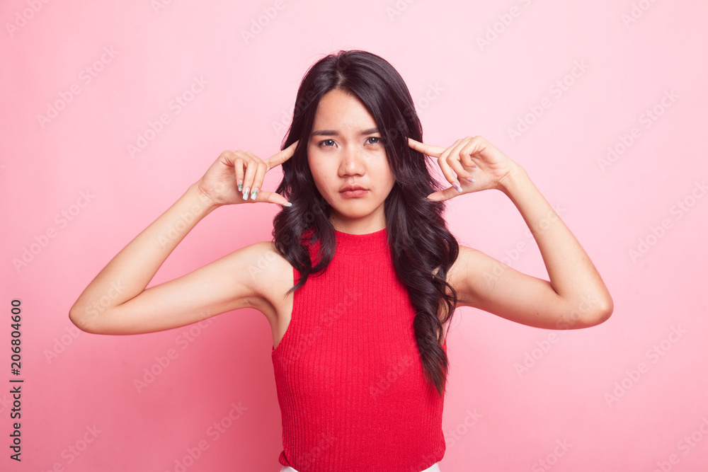 Young Asian woman block both ears with fingers. Young Asian woman block both ears with fingers.