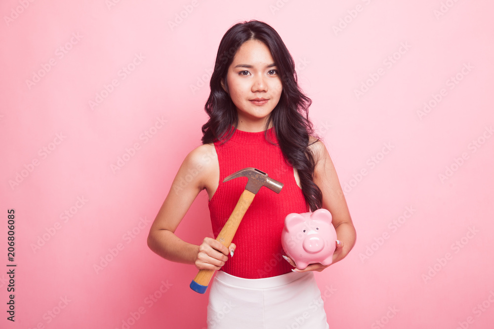Asian woman with pig coin bank and hammer. Asian woman with pig coin bank and hammer.