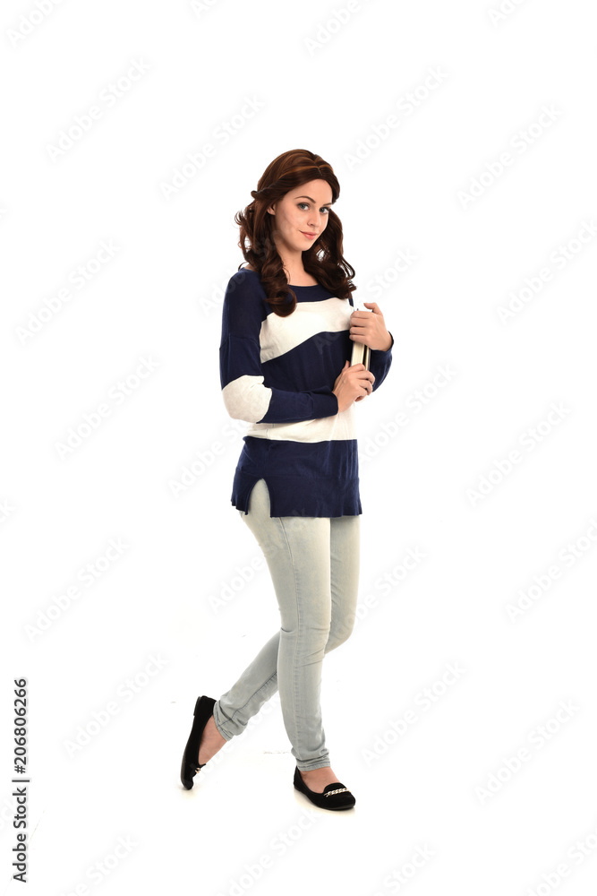full length portrait of girl wearing striped blue and white jumper and jeans and holding a book. standing pose on white studio background full length portrait of girl wearing striped blue and white jumper and jeans and holding a book. standing pose on white studio background