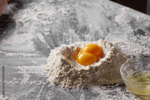 Two yolks and flour on the kitchen table. Ingredients for dough.
