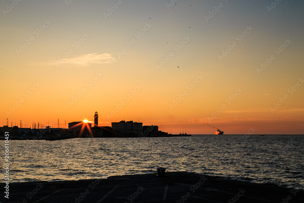 Colorful sunset in front of the city of Trieste