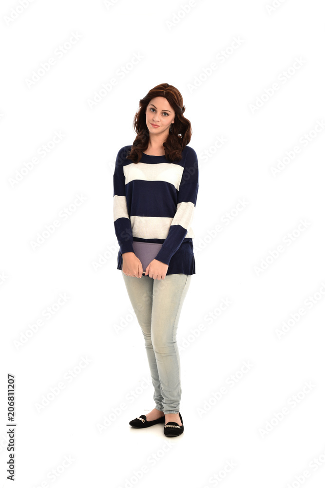 full length portrait of girl wearing striped blue and white jumper and jeans and holding a book. standing pose on white studio background full length portrait of girl wearing striped blue and white jumper and jeans and holding a book. standing pose on white studio background