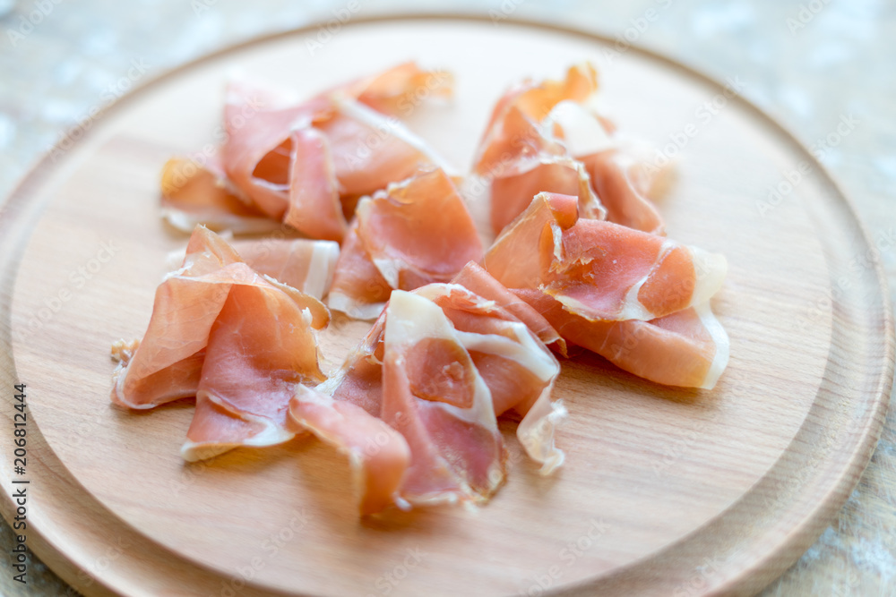 Italian jamon on wooden round board Italian jamon on wooden round board
