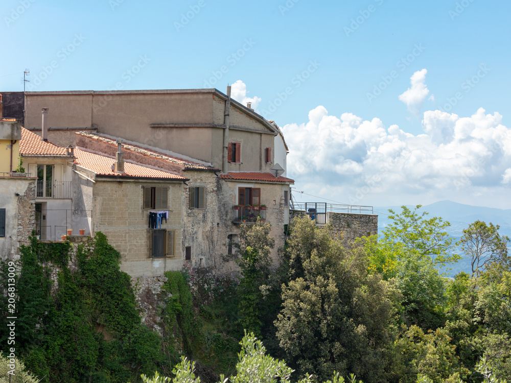 Old Houses Perched on the Edge of a Moutain in the town of Castello Del Matese, Italy Under a Bright Blue Sky