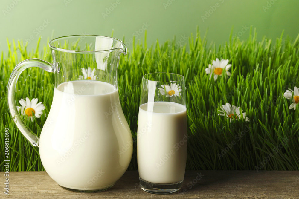 Glass of milk and jar on flower meadow Glass of milk and jar on flower meadow