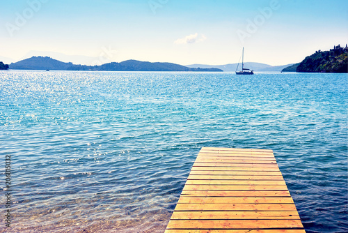 Beautiful scenic landscape with a boat in the bay and a wooden pier near Nydri, Lefkada, Greece. Stunning amazing charming places. prominent tourist towns.